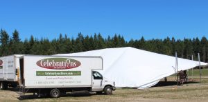 large white tent being set up by Celebrations with their truck parked in front