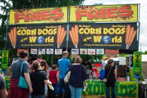 crowd of people at a corn dog stand at the Lacey Spring Fun Fair