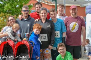 Group of family with racing numbers from a fun run put on by the Family Support Center