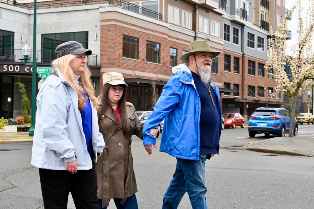 a group of people walking in downtown Olympia by Harbor Heights
