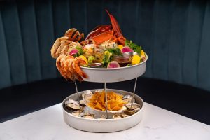 assortment of seafood on a tiered tray on a table at Chelsea Oyster Bar