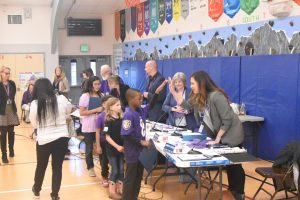 elementary students at Mountain View Elementary in gym with long tables set up, speaking to North Thurston board members 