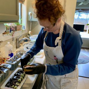 Hannah Whidden putting toppings on her soaps in molds