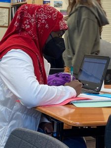 Rahma Gayer sitting at a desk with a laptop