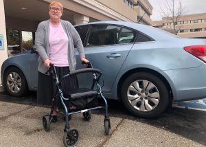 Cheryl Marks with her walker by a blue car