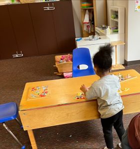 young child doing a wood puzzle on a table at South Sound Parent to Parent