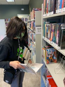 Youth browsing books at Hawks Prairie Timberland Regional Library