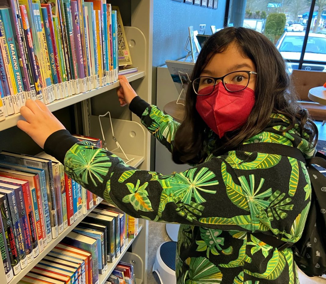 Youth browsing books at Hawks Prairie Timberland Regional Library