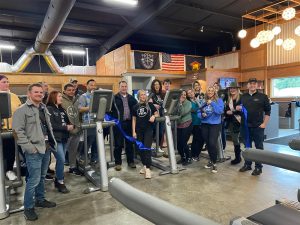 Get Fit Yelm grand opening with crowd of people around ellipticals 