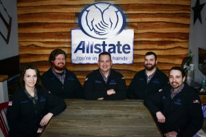 members of the Red White Blue Allstate Team sitting at a table with Allstate logo in the background
