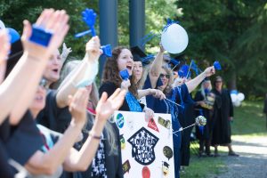 line of people outside celebrating South Puget Sound Community College Graduates with flags, balloons and banners