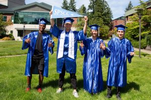Four South Puget Sound Community College graduates in caps and grows