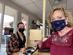 a lady holding up a make up package at Merle Norman Cosmetics