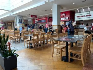 capital mall food court with people eating at tables.