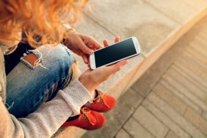 person holding a phone while sitting down