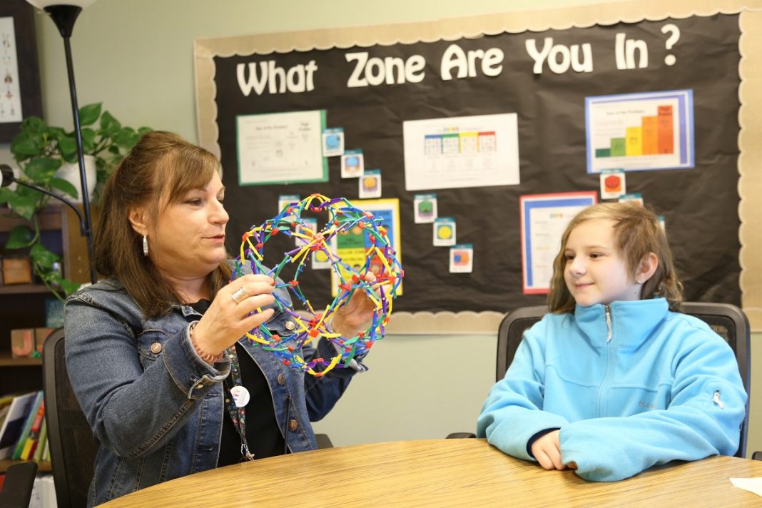 Counselor JJ Pritchett meets with an Olympic View Elementary student. at a table.