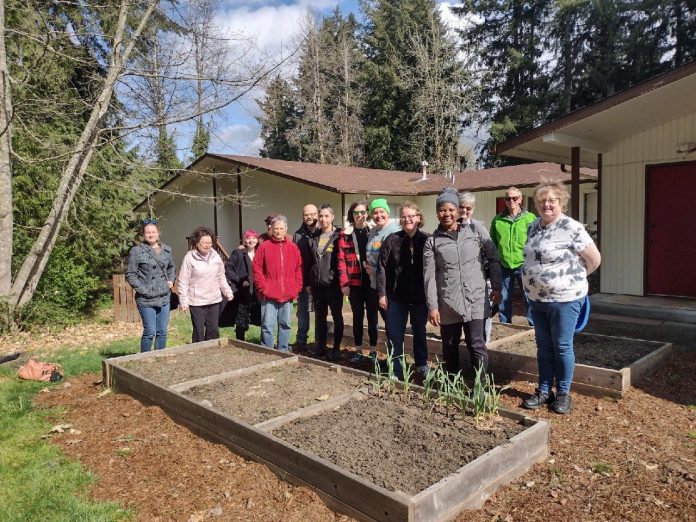 Orientation 4.2.2022 gardeners, garden committee members and Angela Jefferson from Tumwater City Council stand behind raised garden beds