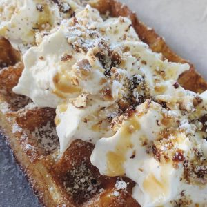 Belgian waffles with whipped cream and caramel drizzle at  Honeycuspe