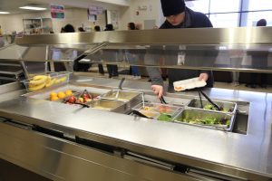 A salad bar with a student getting food at North Thurston Public Schools