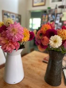 two bouquets of flowers in jugs on a wood table at Winter Creek Farm
