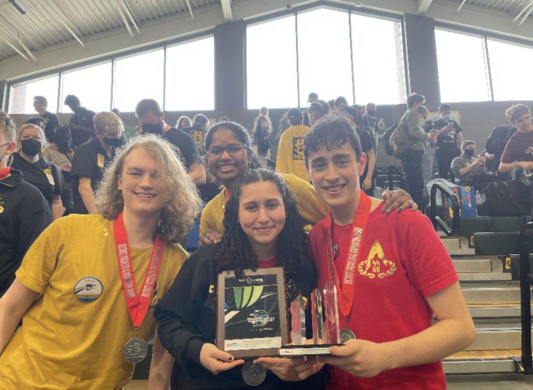 three members of the Thurston County Robotics team holding trophies