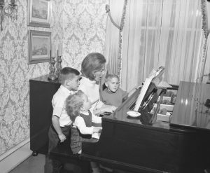 La Première Dame Nancy Evans, vue ici en 1968 jouant du piano au Governor's Mansion avec ses fils