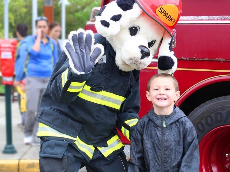 person dressed as Sparky, the Dalmatian mascot for Thurston Fire with a kid