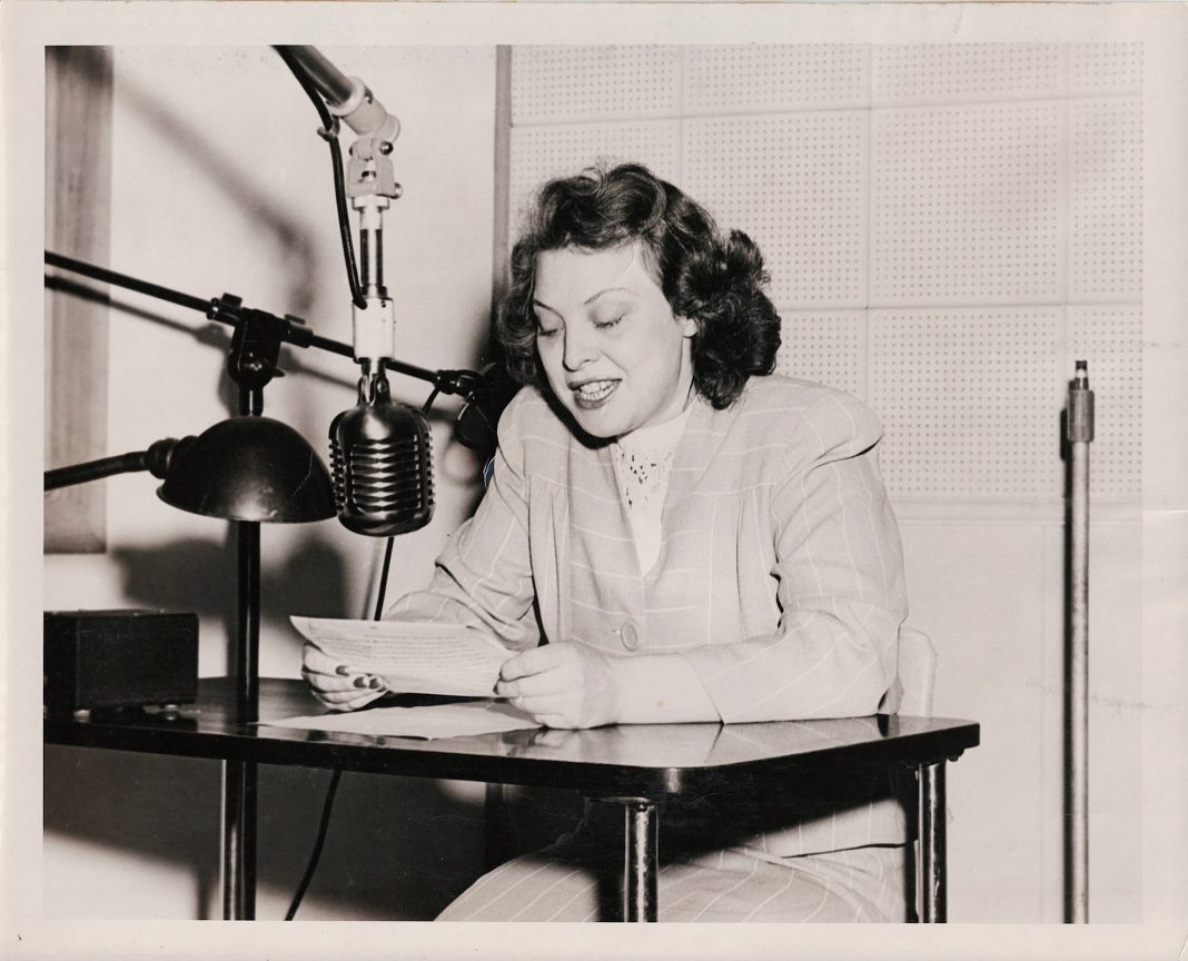 Evie Salathe sitting at KGY radio table in the 1940s