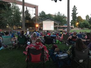 a crowd at Huntamer Park in Lacey watching a movie on a bit outdoor screen