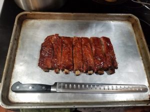 barbecue steak on a metal sheet with a knife in front