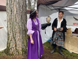 A women holding a falcon on her arm at a renaissance faire