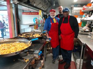 Paella Pro owner Tony Judah is helped by Jack Lennox and Stephen Lawson at the Olympia Farmers Market