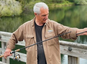 Scott Jones holding a fishing pole on the dock at Lake Sylvia