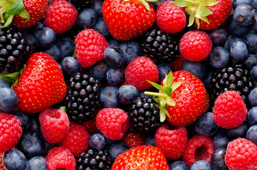 a bunch of strawberries, raspberries and blueberries, close up