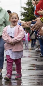 young girl laughing while being cheered by the crowd at the Day of Champions