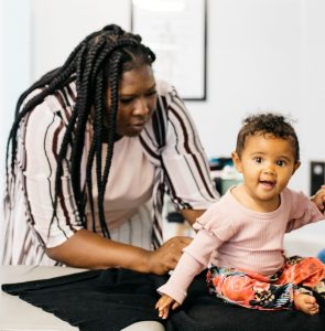 Doctor performing chiropractic on an infant sitting up