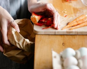 person scraping food off a cutting board