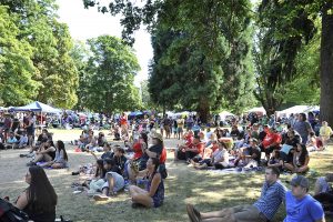 big crowd of people sitting in grass at MOSIAC cultural celebration in Tacoma