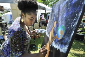 woman painting at MOSIAC cultural celebration