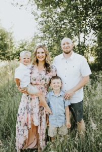 Josh and his wife Marcia with their two kids standing in a field