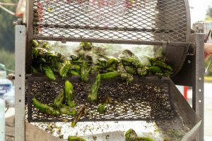 Hatch chiles roasting in a metal roaster at Olympia Thriftway stores