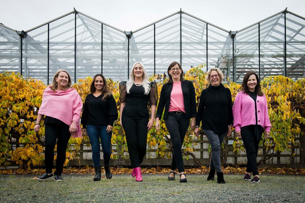 The team at The W Marketplace standing in front of a large glass greenhouse