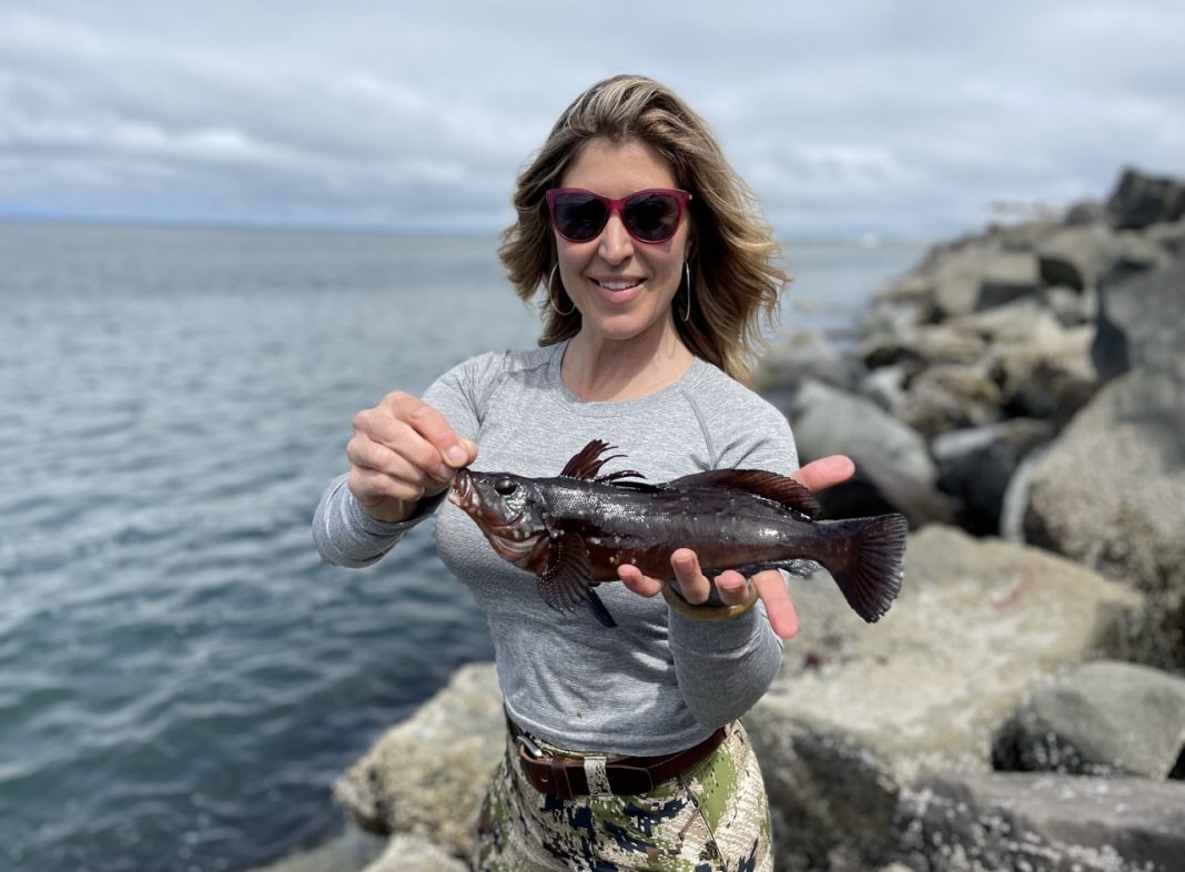 Jess Caldwell holding a kelp greenling at Westport