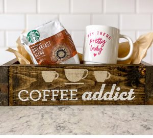 wooden box with the words "coffee addict" on it with a cup and coffee beans inside it at the board and Brush