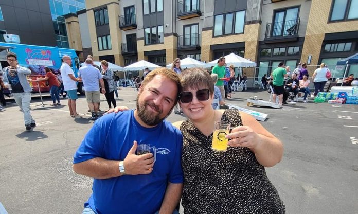 two people sitting outside with glasses of cider at Oly Cider Fest