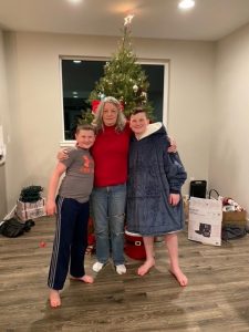 Dora Hinchcliffe with her grandchildren Carter and Hayden in front of a Christmas tree