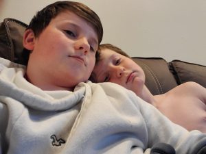 two boys on a couch cuddling