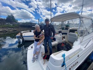 older couple on a boat with their dog