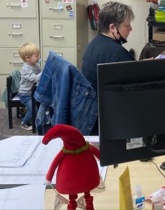 child at a small desk while women is sitting at a big desk working at Lincoln Creek Lumber