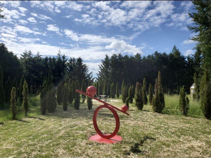 a red metal sculpture at Monarch Park in Tenino
